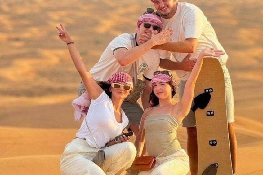 A group of people in a desert setting with a large wooden board. 1