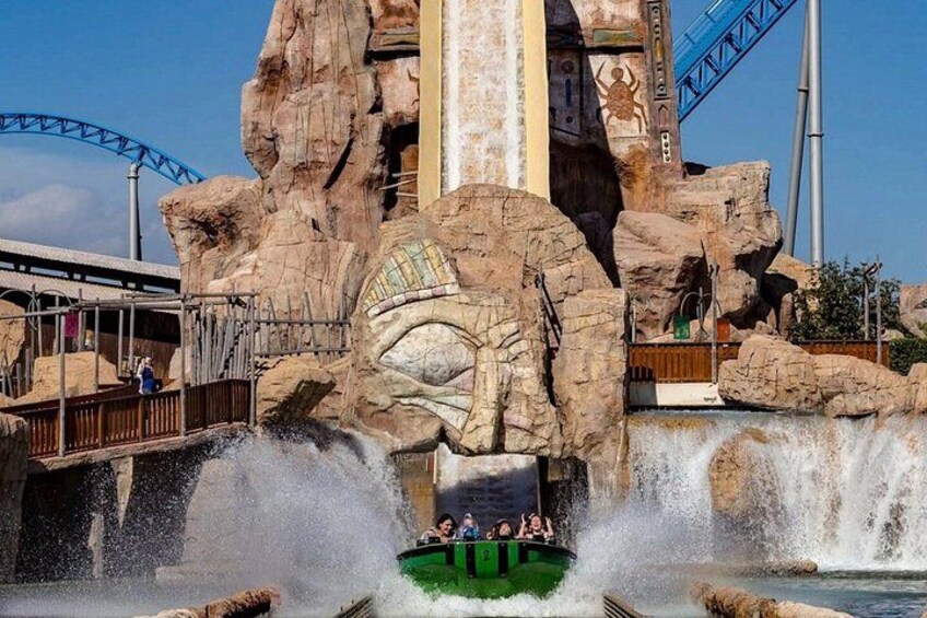 A roller coaster, a large rock formation, and a water splash. 3