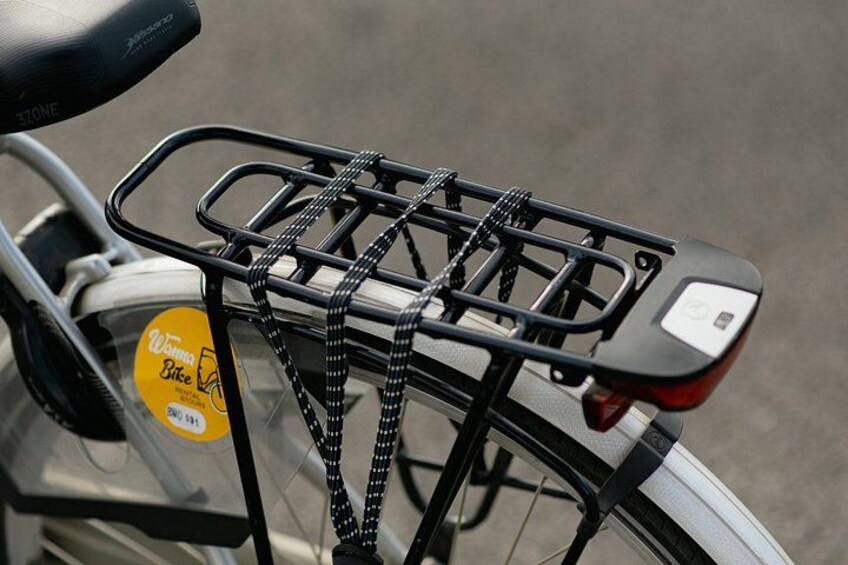 A bicycle with a rear rack and a yellow sticker on the seat. 4