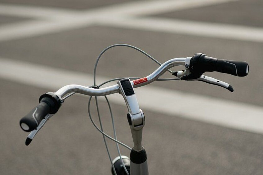 A bicycle handlebar with brake levers and a gear shifter. 5