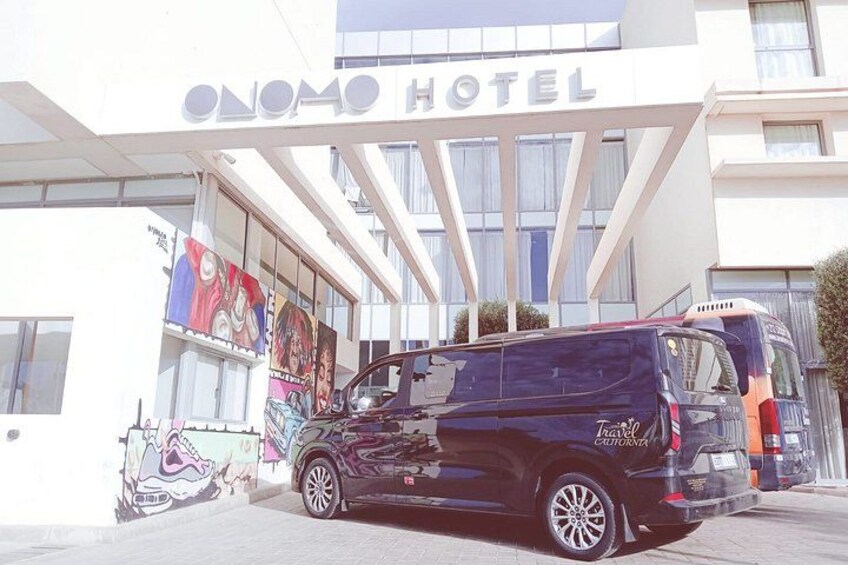 A hotel named 'ONOMO HOTEL' with a black van parked in front. 3