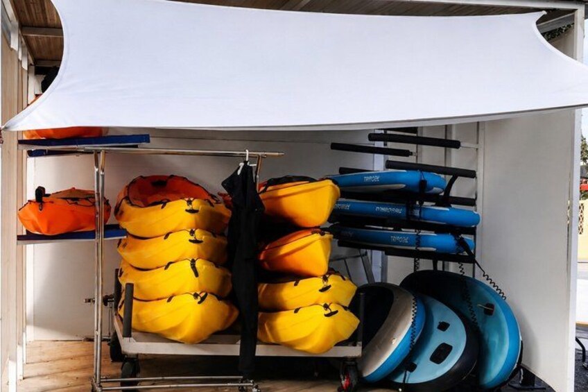 A storage area with yellow and blue kayaks and a black jacket. 1