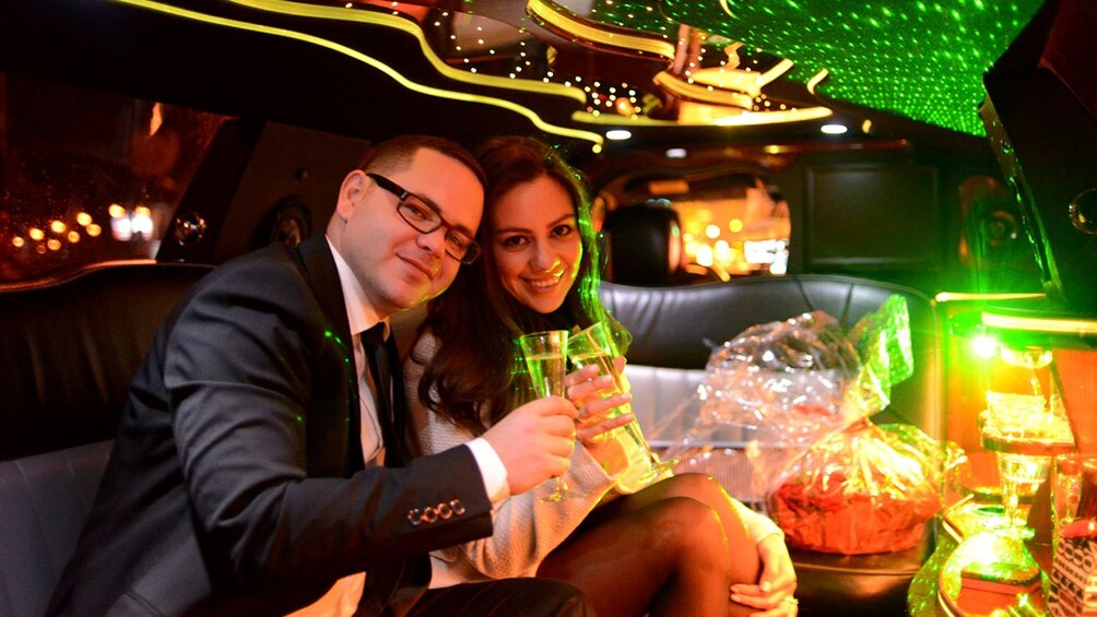 Couple toasting with champagne in a limo in Paris 5