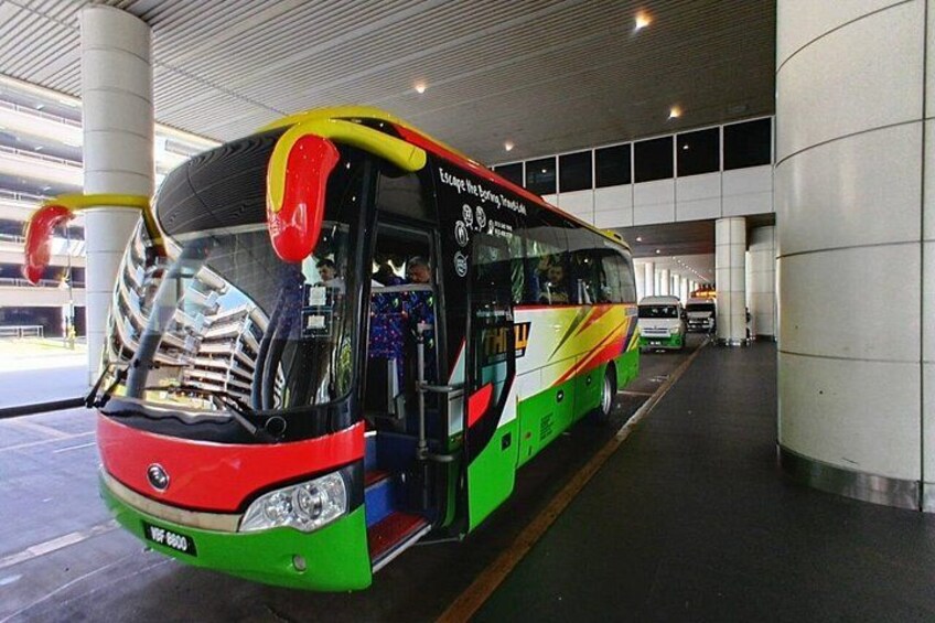 A colorful bus parked inside a covered area with a modern architectural design. 5