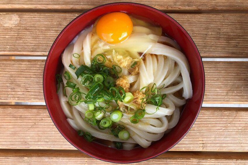 A bowl of ramen with noodles, an egg, green onions, and a fried egg on top. 4