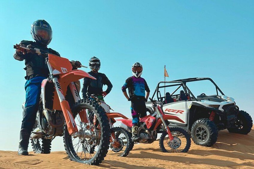 A desert landscape with off-road vehicles and riders. 3