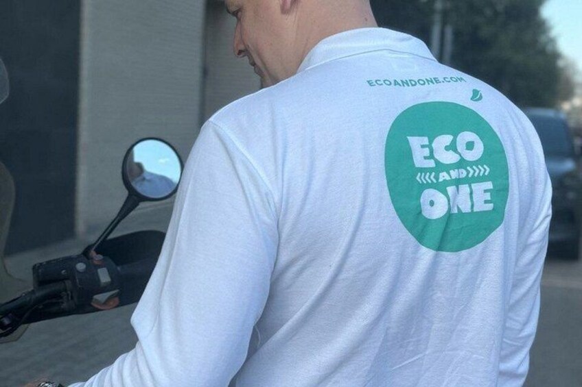 A person wearing a white long-sleeve shirt with a green circular logo on the back that reads 'ECO ONE'. 5