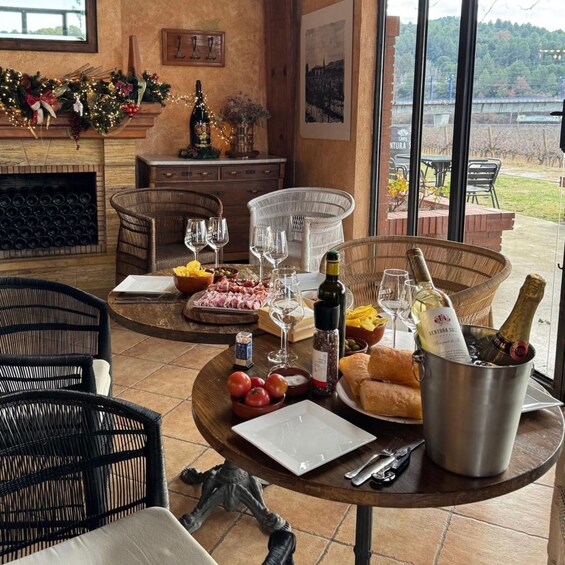 Un comedor con sillas de mimbre, una mesa dispuesta con copas de vino, una botella de champán y una chimenea. 5