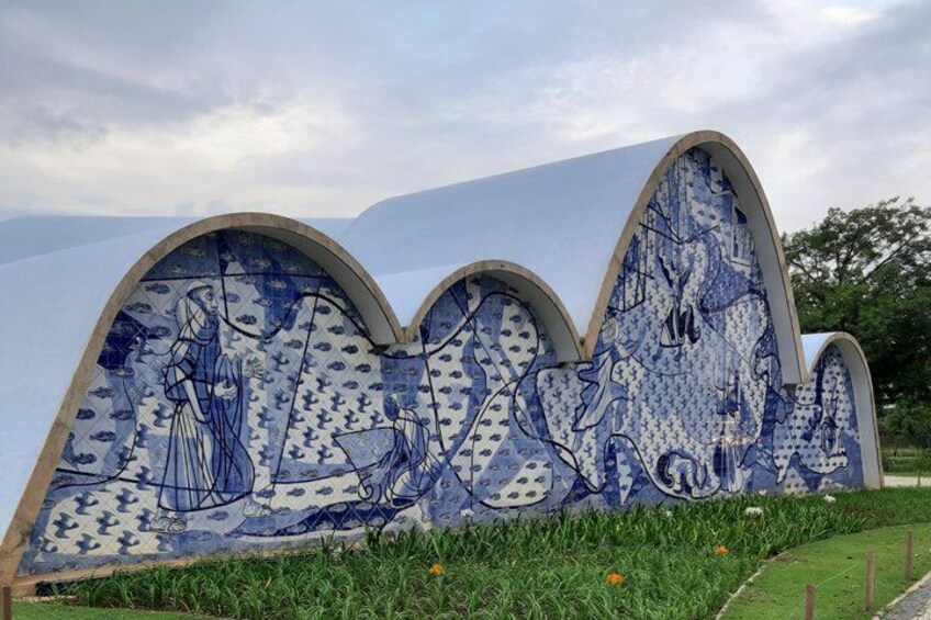A tiled wall with a blue and white pattern, featuring a woman and a horse. 5