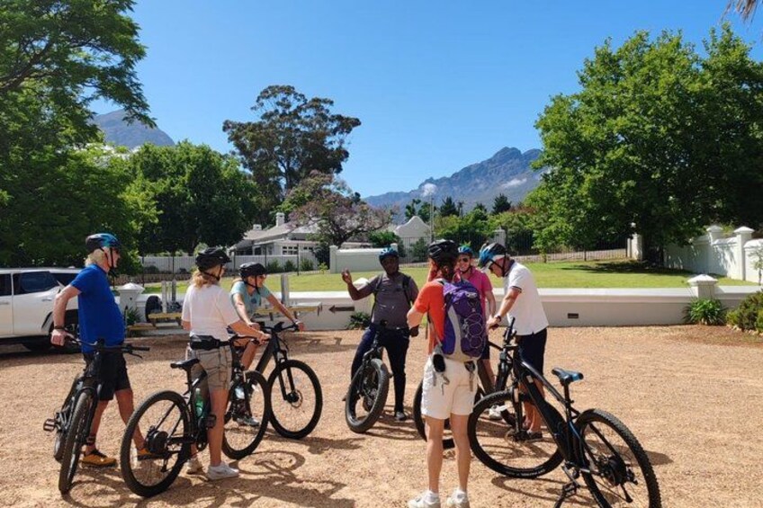 A group of people on bicycles in a parking lot with a mountain in the background. 3