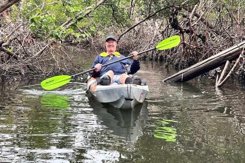 A person kayaking in a mangrove area. 3