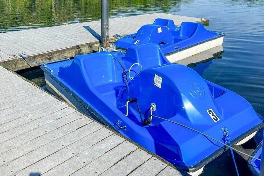 A blue inflatable boat docked at a wooden pier. 2
