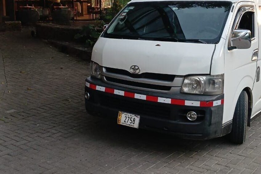 A white van parked on a paved street. 4