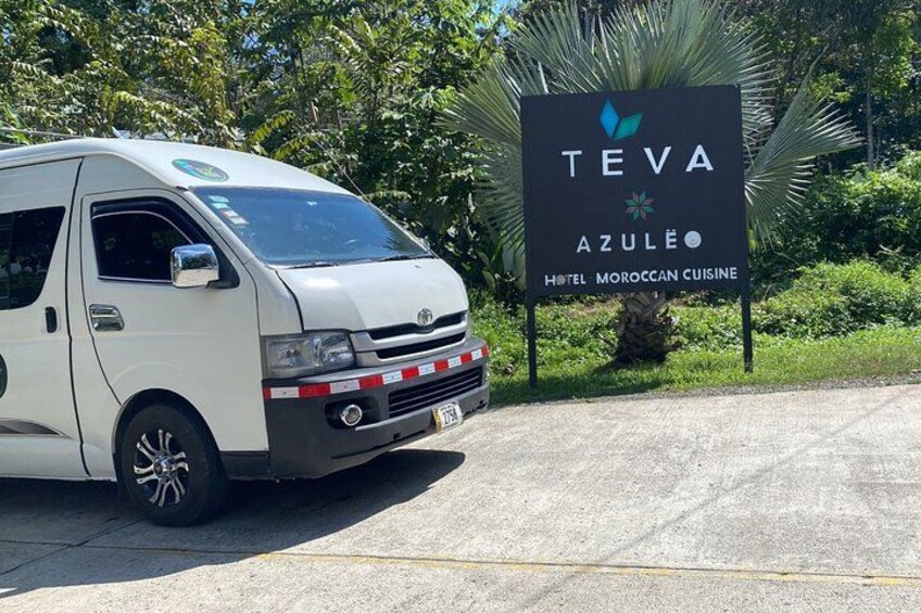 A white van parked in front of a sign for Teva Azule Hotel. 5