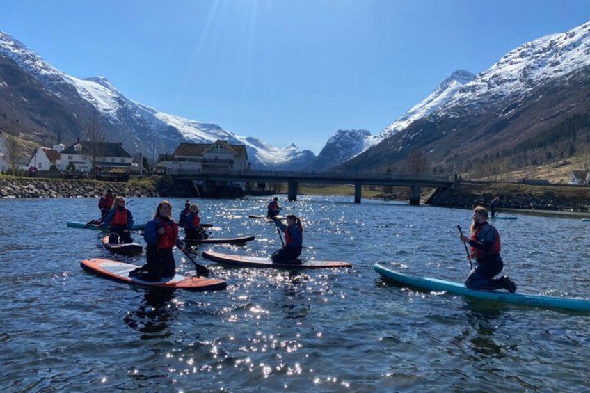 People on paddleboards in a lake with mountains in the background. 5