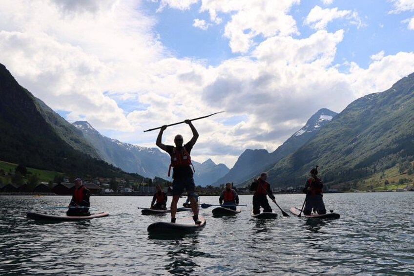 A group of people on paddleboards in a lake surrounded by mountains. 4