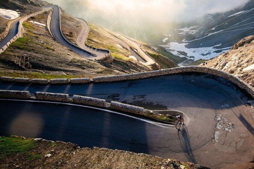A winding mountain road with a cyclist. 4
