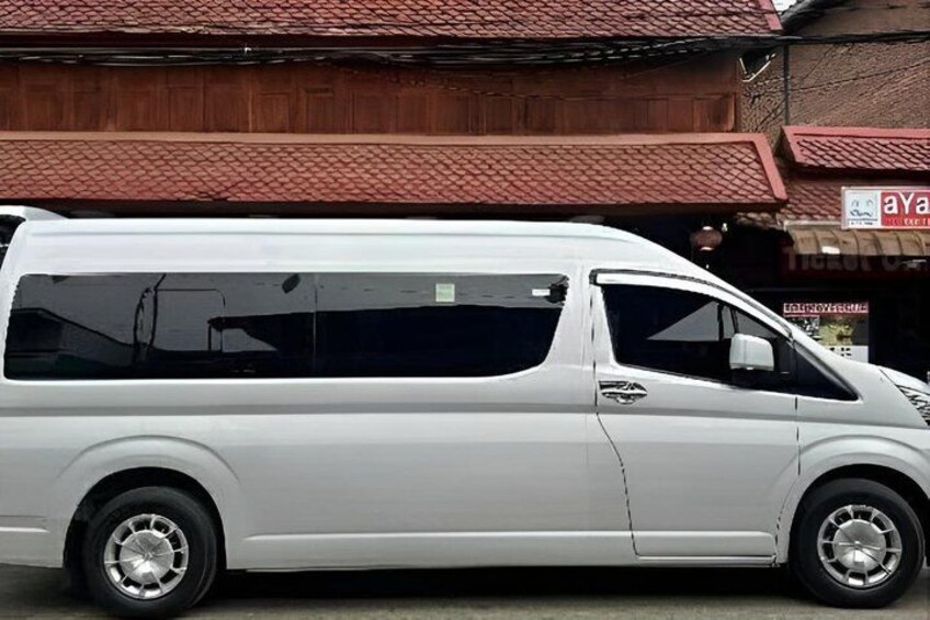 A white van parked in front of a building with a red roof and a sign that reads 'aYa'. 1