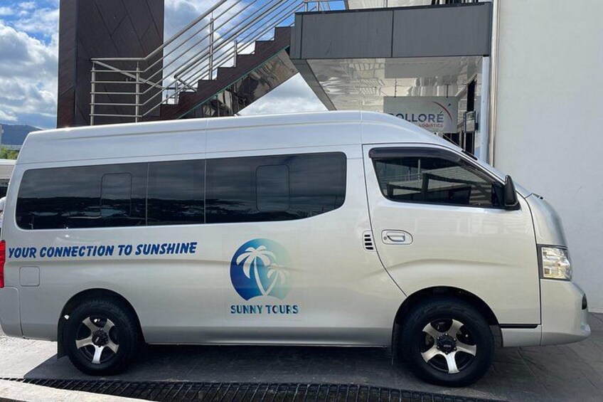 A white van parked in front of a building with a logo and text on its side. 1