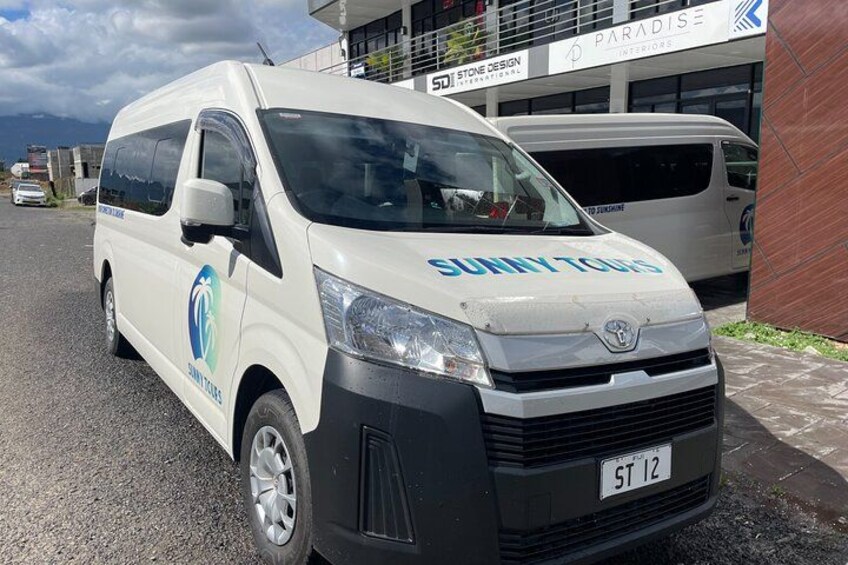 A white van with 'Sunny Tours' branding parked on a street. 2