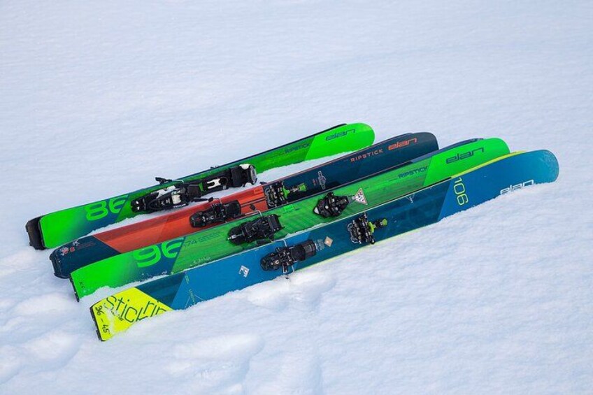 Three pairs of skis lying on snow. 4