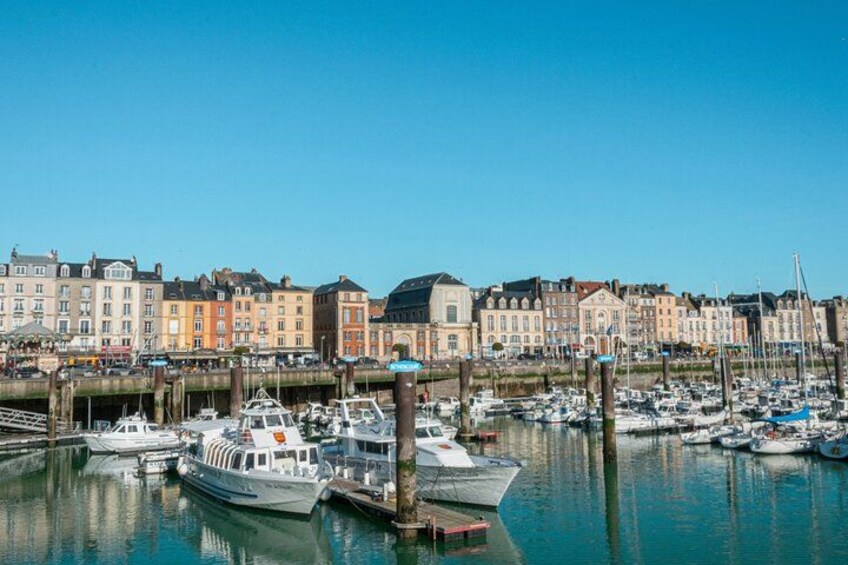 A marina with boats docked, a clear blue sky, and historic buildings along the waterfront. 5