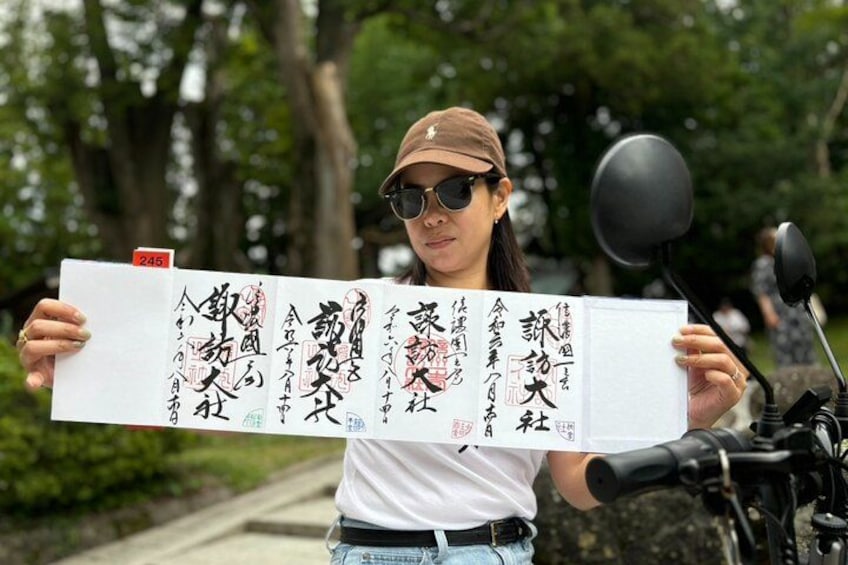 A person holding a large sheet with Chinese calligraphy. 4