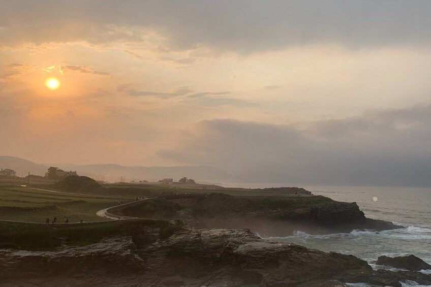A coastal landscape with a winding road, rocky cliffs, and the ocean. 2