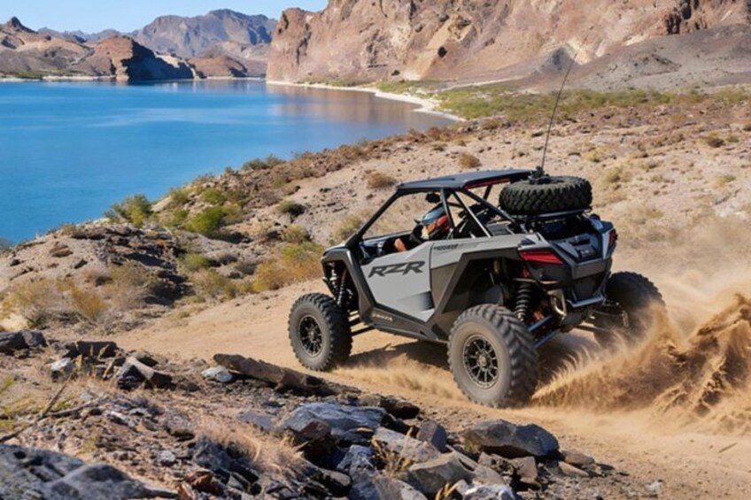 A rugged off-road vehicle on a rocky terrain near a body of water. 4