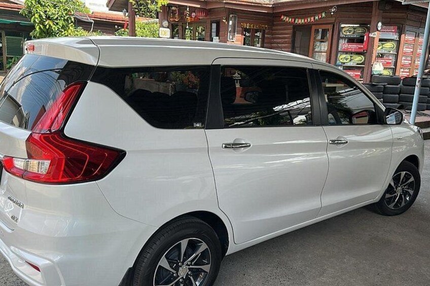 A white SUV parked in front of a building with signage. 2