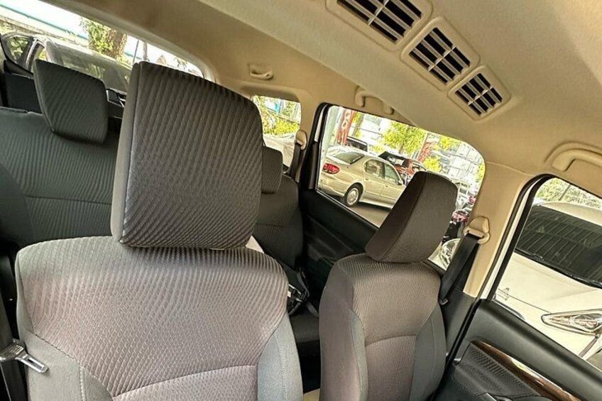 The interior of a car with grey seats and a sunroof. 3