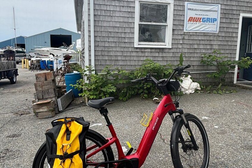 A red bicycle parked in front of a building with a sign that reads 'AWL GRIP.' 1