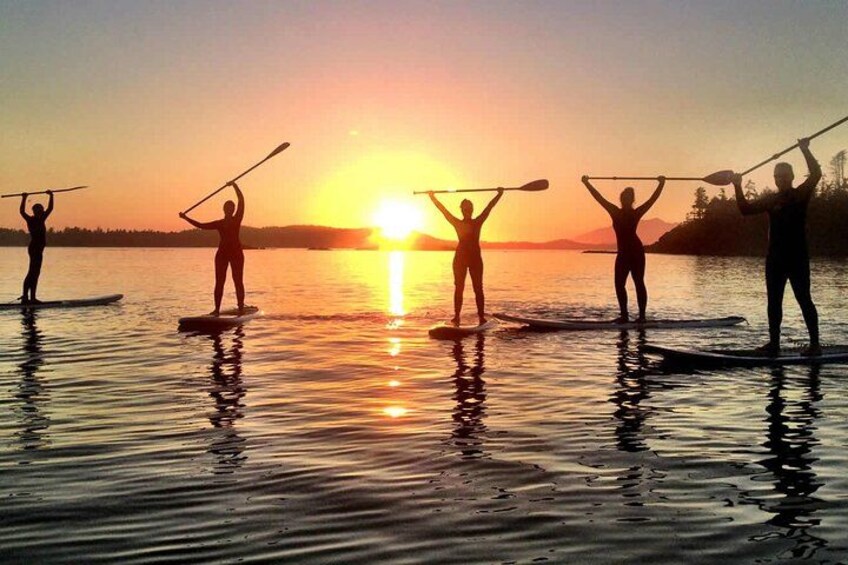People paddleboarding at sunset. 2