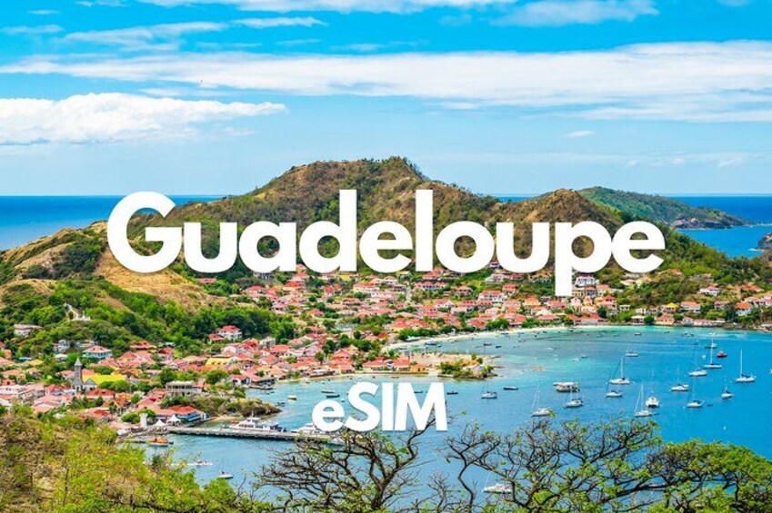 Guadeloupe with a coastal town, clear blue waters, and boats. 1