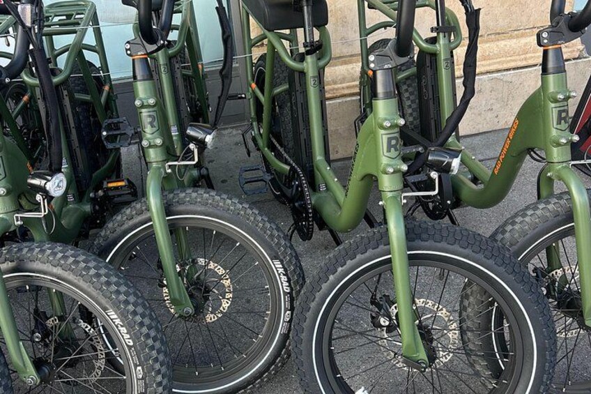 A row of green electric bicycles parked in a row. 2