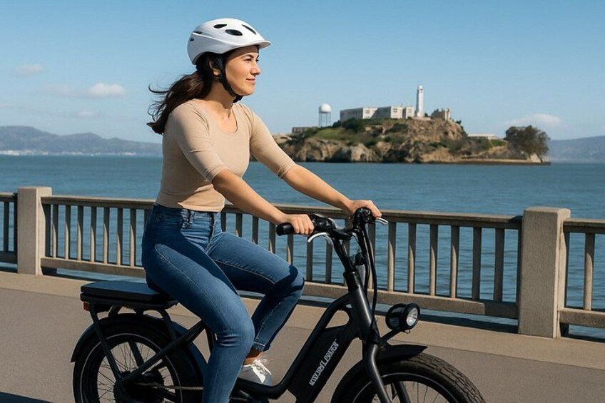 A person riding a stationary bike on a bridge with a coastal landscape in the background. 4