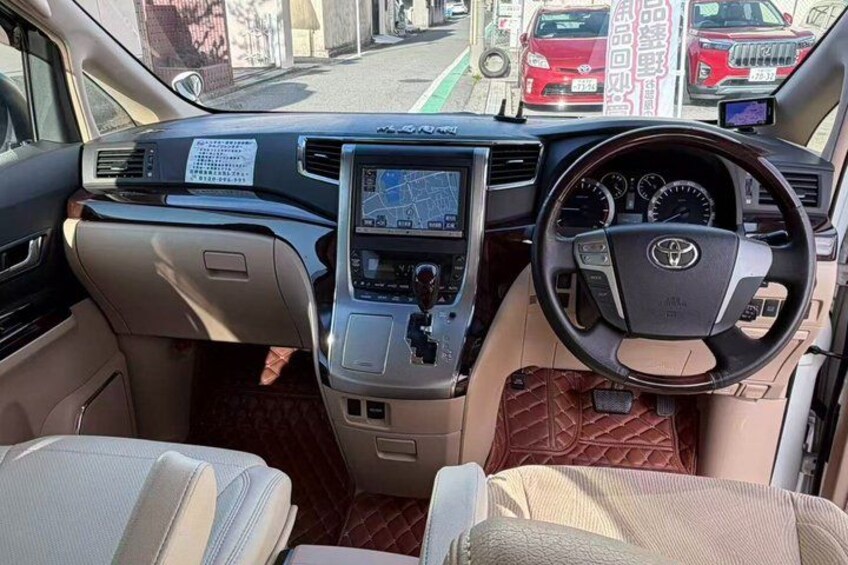 The interior of a vehicle with a steering wheel, dashboard, and center console. 3