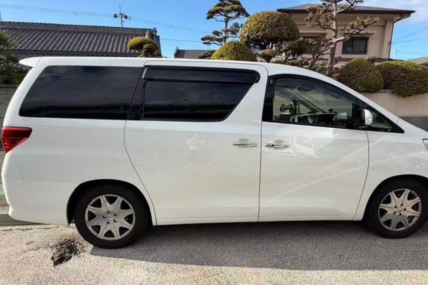 A white minivan parked on a street. 1