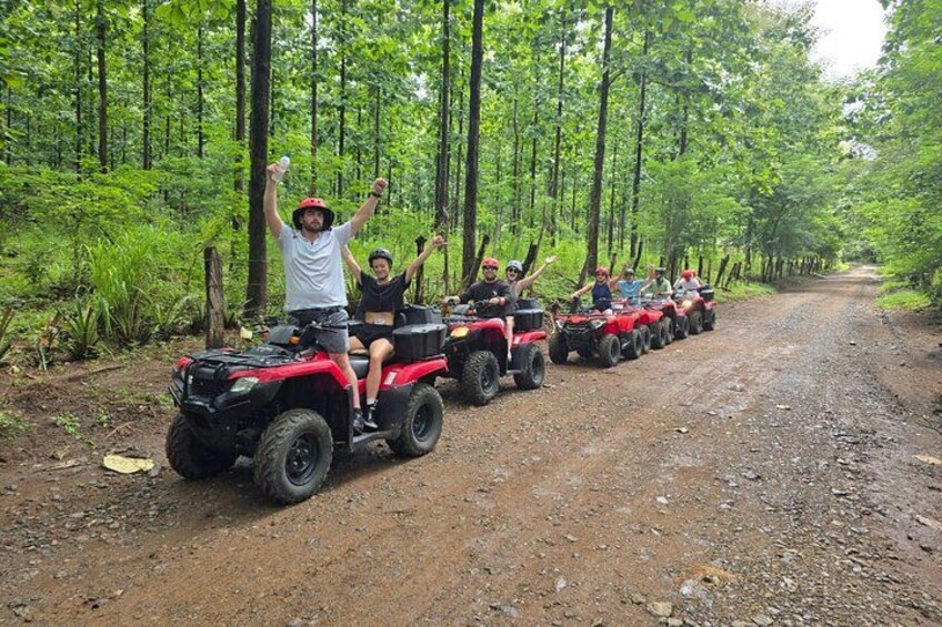 A group of people on red ATVs in a forested area. 4