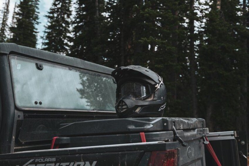 A black vehicle with a roof rack and a helmet on top. 4