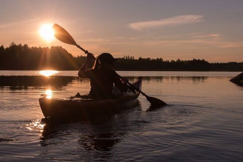 A person kayaking on a calm lake during sunset. 1