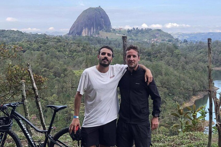 Two people standing with a mountain and a river in the background. 5