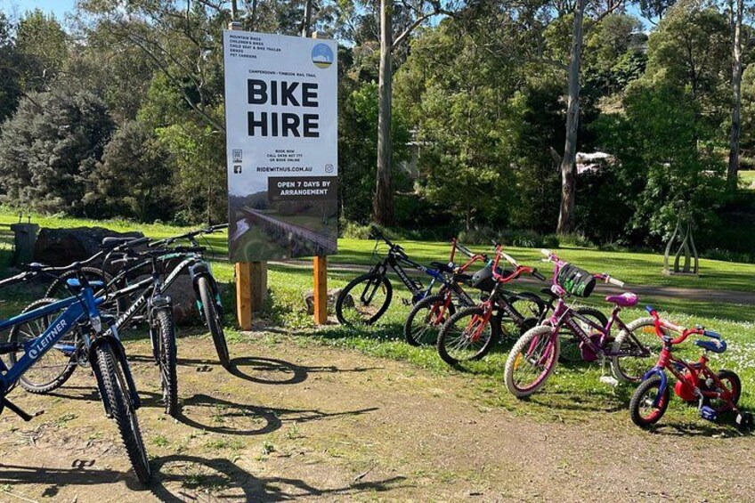 A bike hire sign with multiple bicycles parked nearby. 4