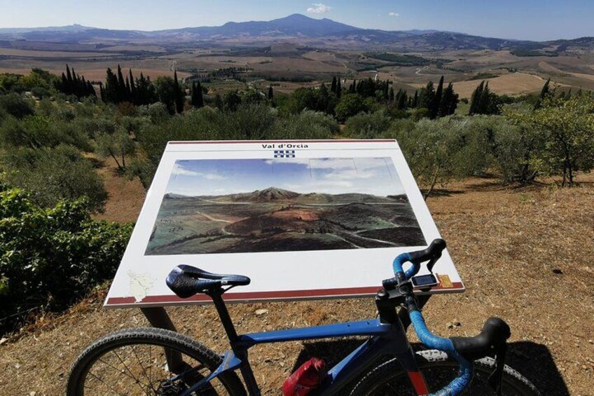A bicycle parked in front of a sign with a landscape view. 2