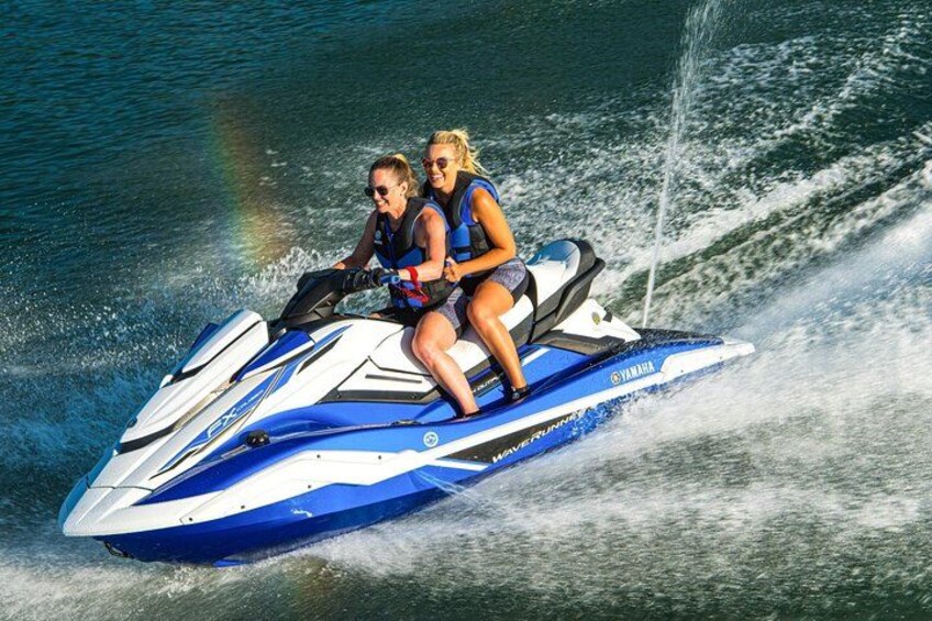 Two people on a blue and white jet ski on water. 5