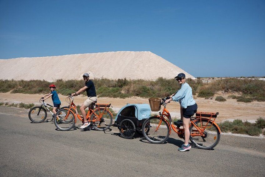 Three people on bicycles, a sandy landscape, and a clear sky. 3