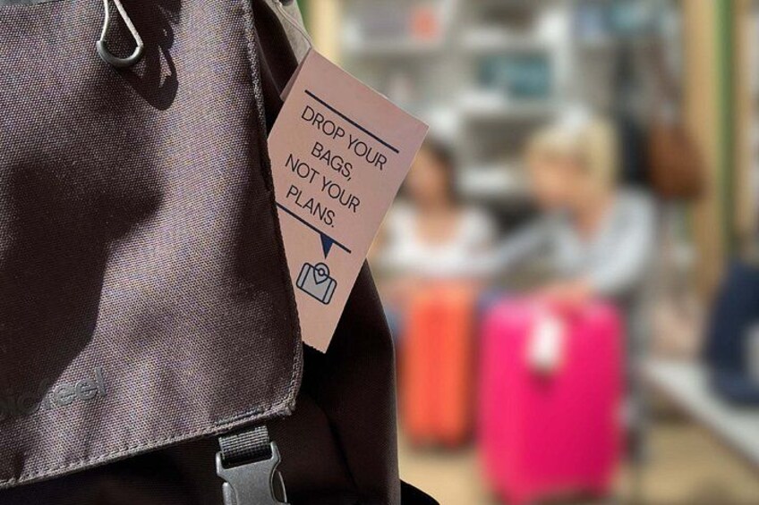 A person carrying a brown bag with a tag that says 'DROP YOUR BAGS, NOT YOUR PLANS.' 5
