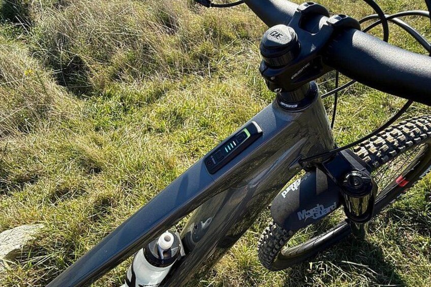 A mountain bike with a digital display, a suspension fork, and a rear derailleur. 3