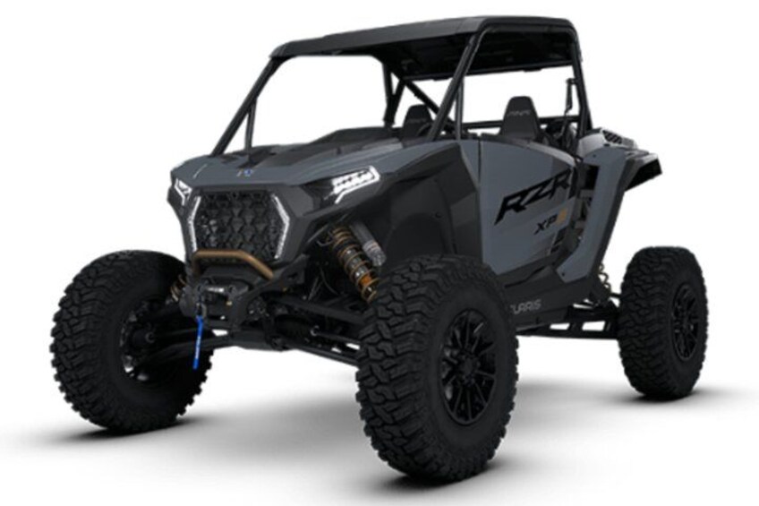 A black Polaris RZR Xp vehicle with large off-road tires, a roll cage, and a spare tire mounted on the back. 3