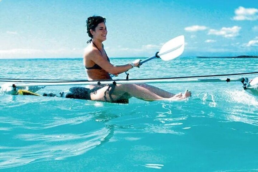 A person kayaking on clear turquoise water with a distant shoreline. 2